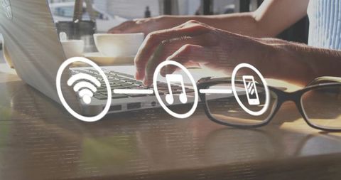 Sunlit cafe coworking typing on laptop with glasses and connectivity icons