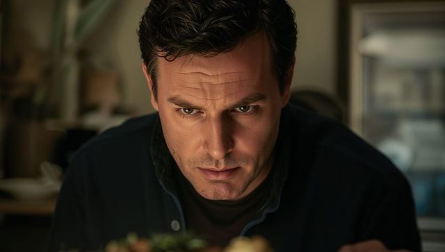 Man inspecting plated dish with focused expression in cozy kitchen, tasting flavors