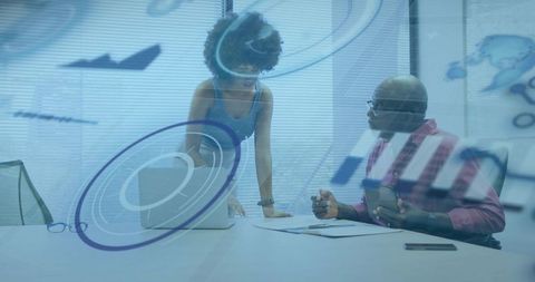 Business professionals collaborating over laptop in modern boardroom with digital overlays
