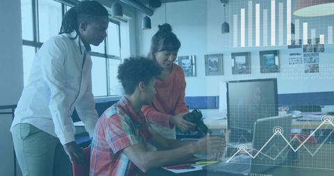 Collaborating team reviewing dslr footage and analytics on laptop in modern coworking office
