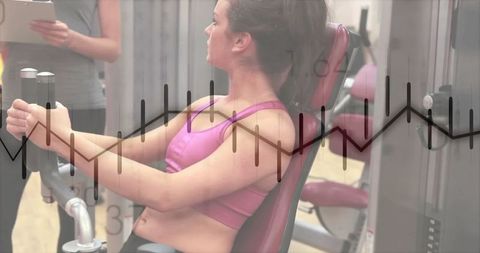 Fit woman strength training on chest press at gym