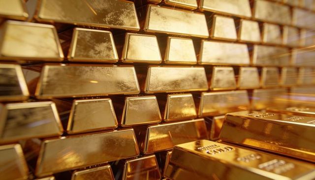 Stacked gold bars reflecting light showing hallmarks and serial numbers luxury bullion vault