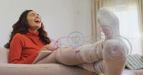 Joyful woman relaxing on couch interacting with social media