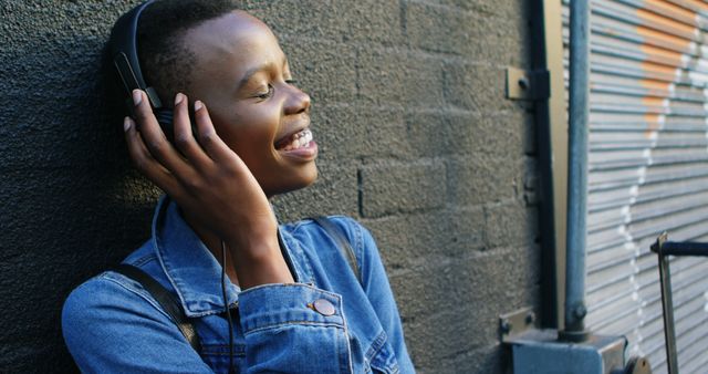 Young Person Enjoying Music on Headphones against Urban Background - Download Free Stock Images Pikwizard.com