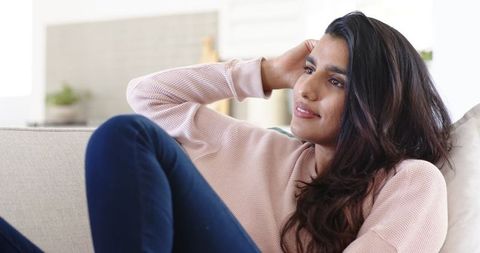 Content Woman Relaxing on Sofa in Cozy Living Space