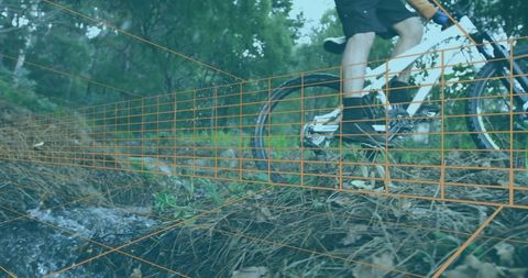 Cyclist riding through forest stream on adventure course