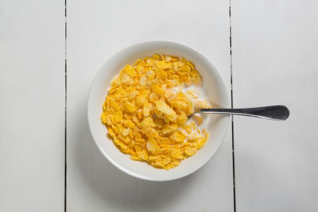 Close-up of Cornflakes with Milk in White Bowl on Wooden Table - Download Free Stock Photos Pikwizard.com