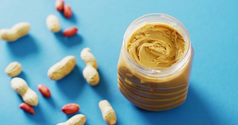Creamy Peanut Butter Jar with Peanuts on Blue Background - Download Free Stock Images Pikwizard.com