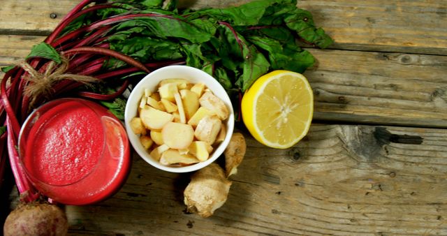 Visually showcasing fresh detox smoothie ingredients including beetroot, ginger, and lemon on rustic wooden table. Highlighting natural and healthy organic produce ideal for wellness and healthy lifestyle content, food blogs, recipe books, and nutritional guides.