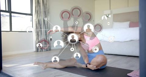 Stretching woman practicing yoga at home with digital social network overlay for wellness