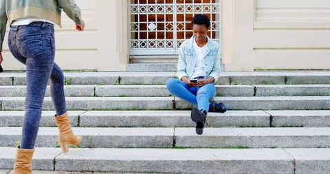 Young Women Enjoying Smartphone Interaction on Urban Steps