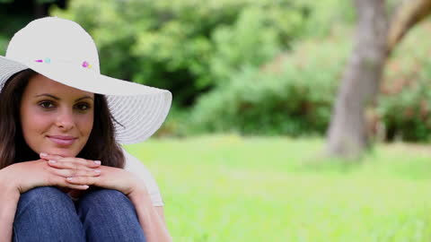 Woman Relaxing in Park with Straw Hat