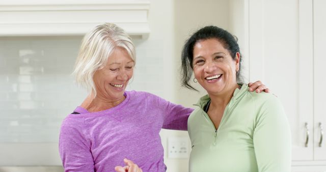 Two happy diverse senior women embracing and smiling in sunny kitchen - Download Free Stock Photos Pikwizard.com