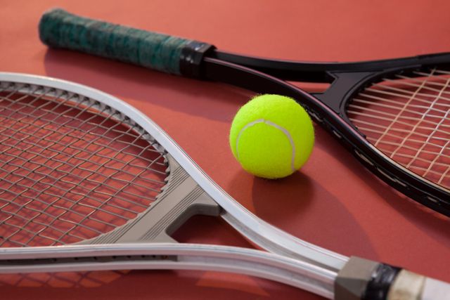 Tennis Rackets and Ball on Maroon Surface - Download Free Stock Photos Pikwizard.com