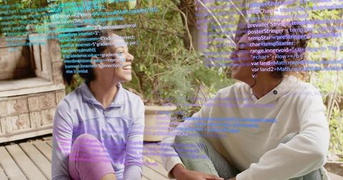 Two women chatting on wooden porch with holographic code overlay, casual companions