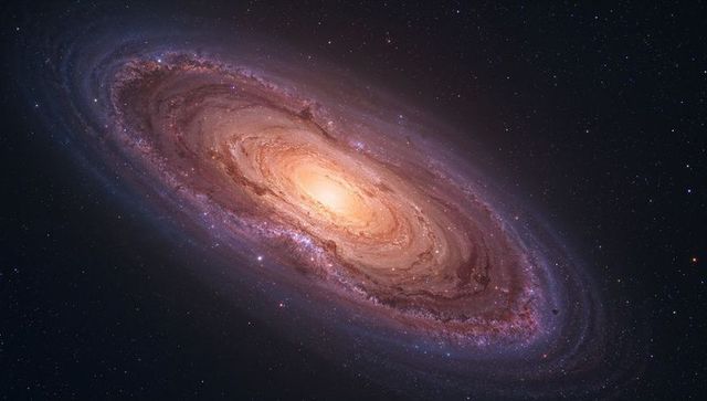 Inclined spiral galaxy unfurling with luminous bulge and dusty arms in starfield
