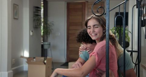 Happy Couple Relaxing Among Boxes in New Home