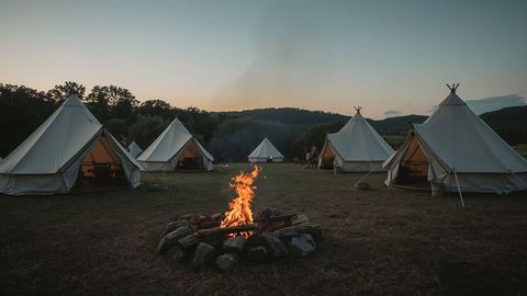 Cozy Campfire and Bell Tents at Dusk in Outdoor Wilderness