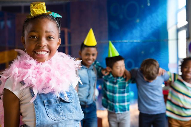 Portrait of girl wearing feather boa with friends in background during birthday party