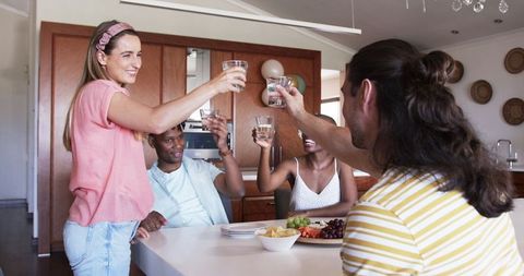 Friends Celebrating Together with Drinks and Snacks at Home