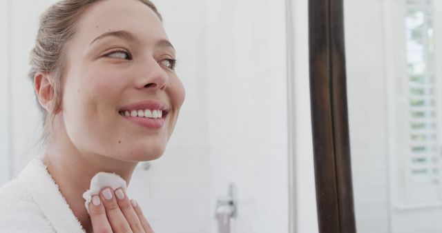 Smiling Young Woman Applying Skincare Product in Bathroom - Download Free Stock Images Pikwizard.com