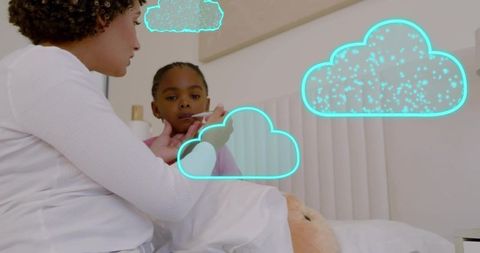 Caregiver taking child's temperature in bedroom with neon teal cloud graphics and teddy bear