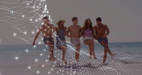 Friends kicking through surf linking arms with sparkling particle trail and summer vibe
