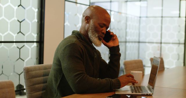 Mature Businessman Making Phone Call in Modern Office While Using Laptop - Download Free Stock Images Pikwizard.com