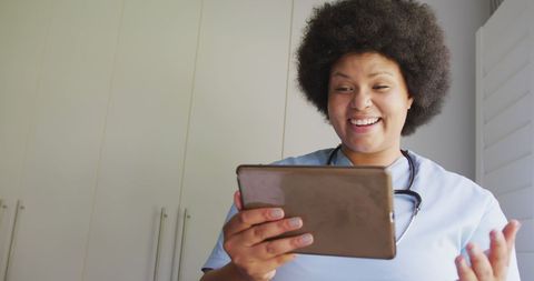 Joyful African American Doctor Using Tablet in Modern Clinic