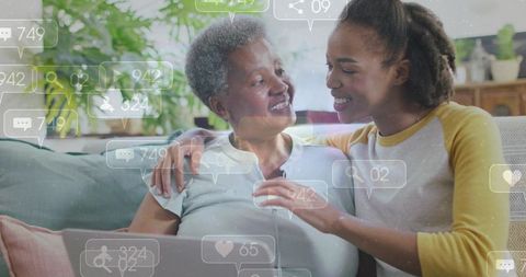African american daughter helping senior mother with laptop while social notifications float