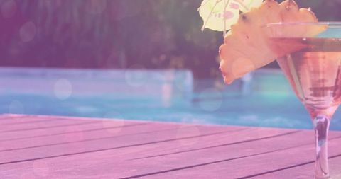 Tropical martini glass poolside with pineapple slice rim