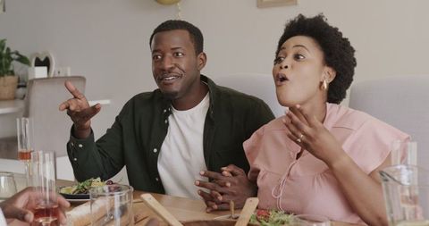 Friends Celebrating with Laughter and Stories at Dinner Table