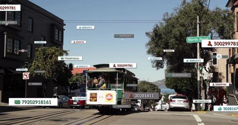 Climbing historic cable car carrying operator and passengers up steep urban waterfront hill