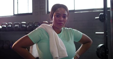 Determined african american woman cooling down after workout with towel hands on hips