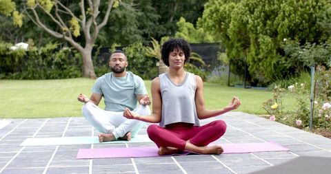 African American Couple Meditating in Garden Yoga Session