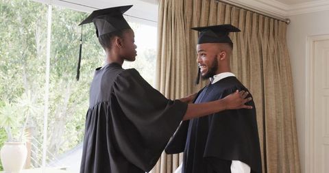 Graduates celebrating at home in academic regalia
