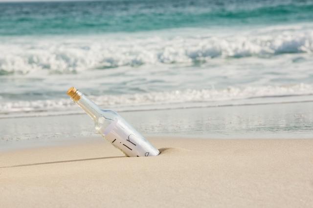 Message in a Bottle Stuck in Sandy Beachfront - Download Free Stock Photos Pikwizard.com