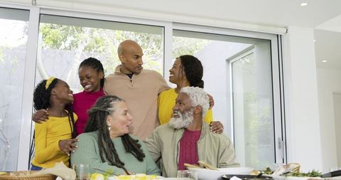 Multigenerational Black Family Gathering Around Sunlit Dining Table Sharing Meal