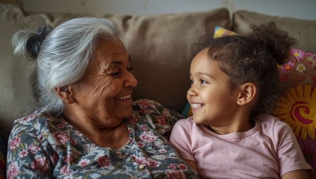 Senior Woman and Young Girl Sharing Joyful Moment on Sofa
