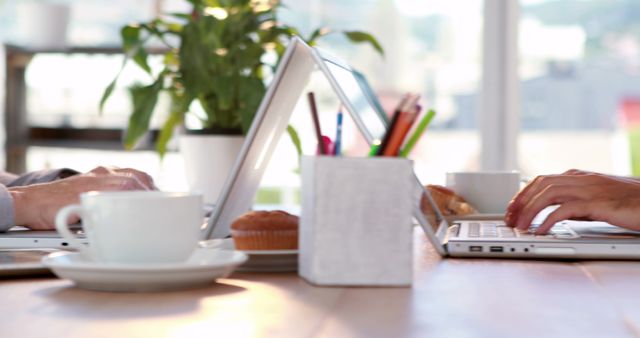 Workspace with Laptops, Coffee, and Muffins, Two People Working - Download Free Stock Images Pikwizard.com