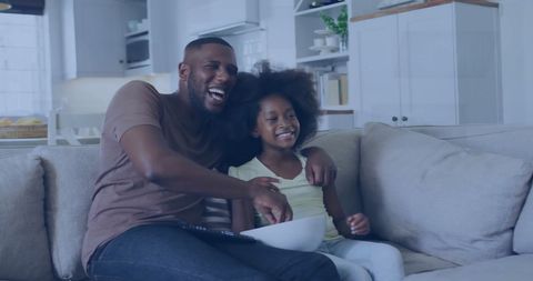 Family time, african american dad and daughter laughing on couch