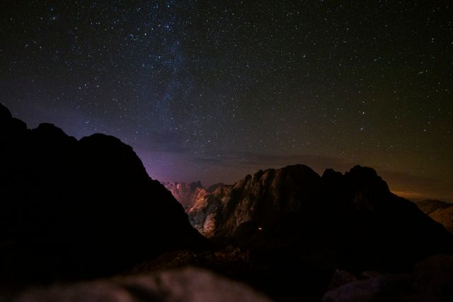 This image showcases a star-filled night sky over a dark mountain range. Perfect for use in nature-themed projects, astronomy discussions, wilderness adventure marketing, or as a calming background for meditative practices.
