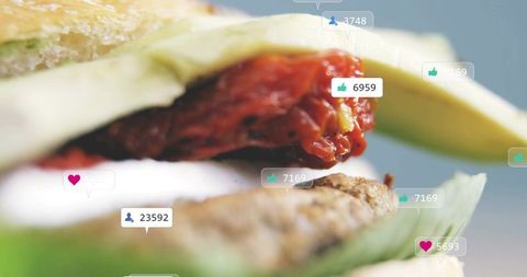 Closeup gourmet burger with avocado and roasted tomato showing social media reactions