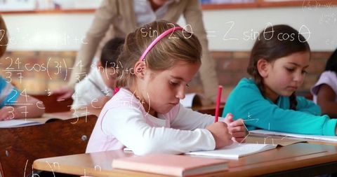 Young schoolgirl focused on math in classroom