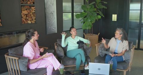 Women podcast panel recording in modern lounge with laptop, microphone and green drinks
