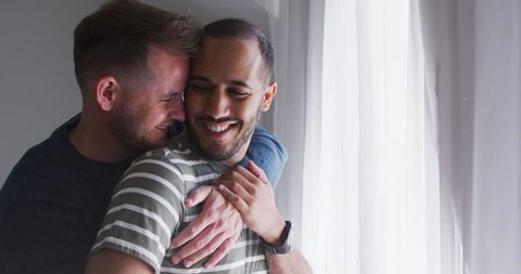 Gay Couple Enjoying Cozy Embrace by Sunny Window