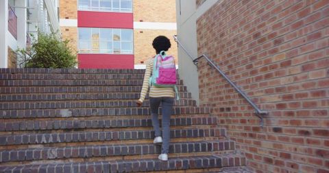 Student Climbing Campus Stairs with Backpack in Urban Setting