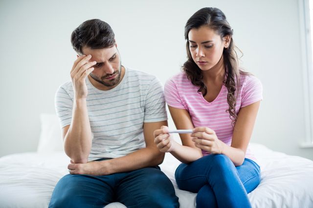 Worried couple finding out results of a pregnancy test in bedroom - Download Free Stock Photos Pikwizard.com