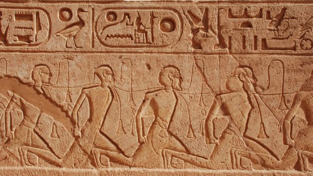Ancient Egyptian hieroglyphs carved on a sandstone temple wall, showcasing intricate symbols and historic art. Suitable for use in educational materials about ancient history and archaeology, decorating spaces with cultural art, or accompanying travel articles focused on Egypt.
