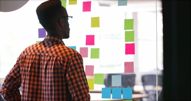 Focused Man Planning with Sticky Notes on Glass - Download Free Stock Images Pikwizard.com